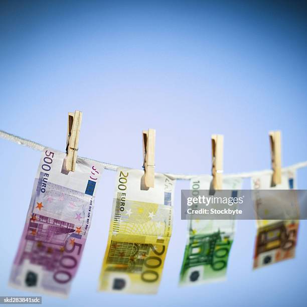 close-up of various euro notes hanging on clothesline - zweihunderteuroschein stock-fotos und bilder