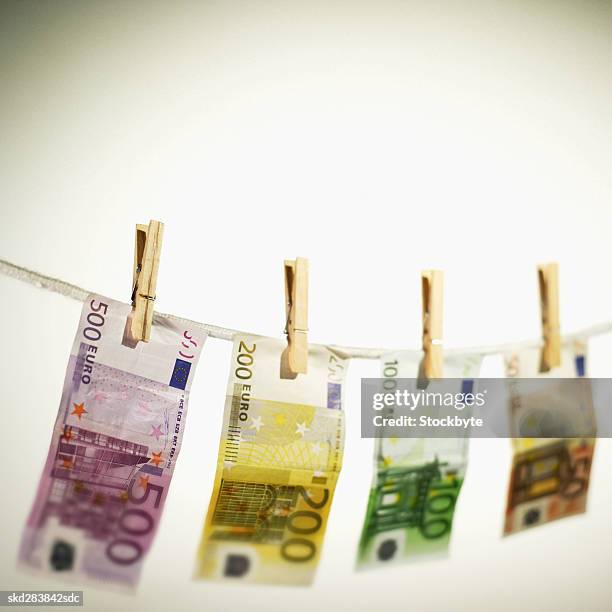 close-up of various euro notes hanging on clothesline - 50 euros stock-fotos und bilder