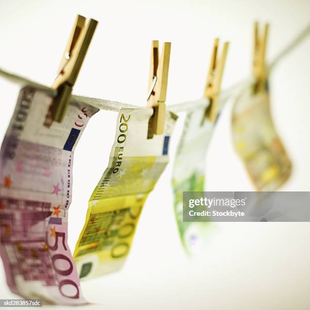 close-up of various euro notes hanging on clothesline - 50 euros stock-fotos und bilder