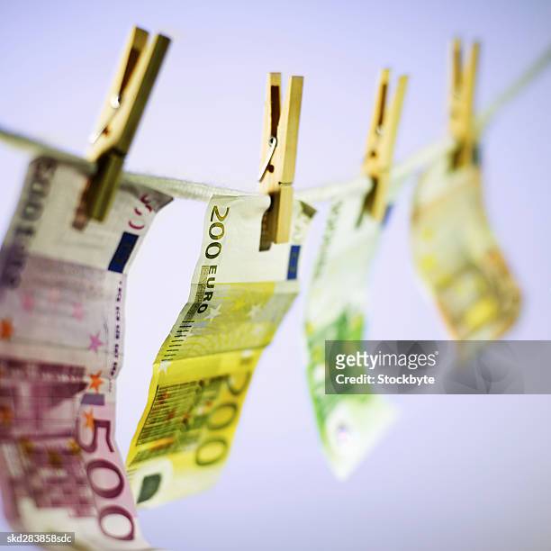 close-up of various euro notes hanging on clothesline - 50 euros stock-fotos und bilder