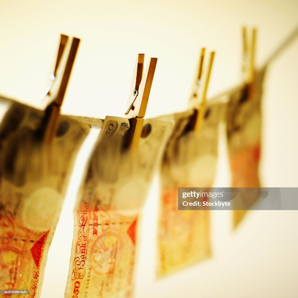 Close-up of fifty pound notes hanging on clothesline