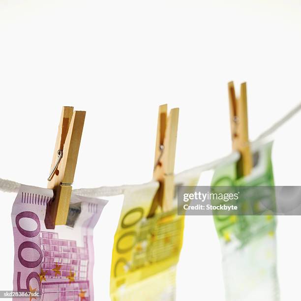 close-up of various euro notes hanging on clothesline - zweihunderteuroschein stock-fotos und bilder