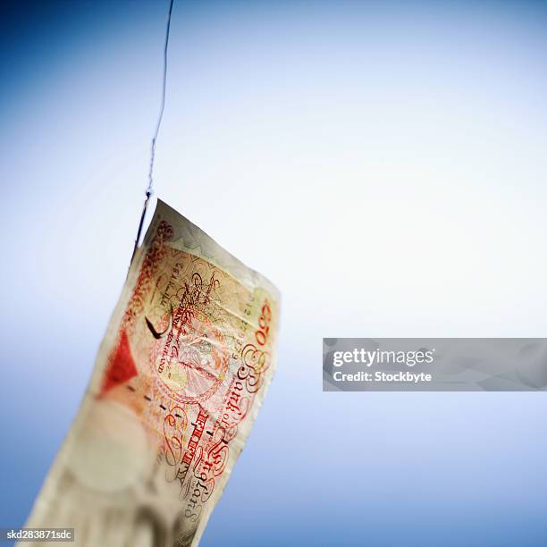 close-up of a fifty pound note hanging on fishhook - 50 pound notes stock pictures, royalty-free photos & images