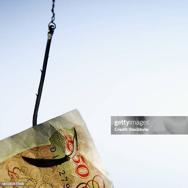 close-up of a fifty pound note hanging on fishhook - 50 pound notes stock pictures, royalty-free photos & images