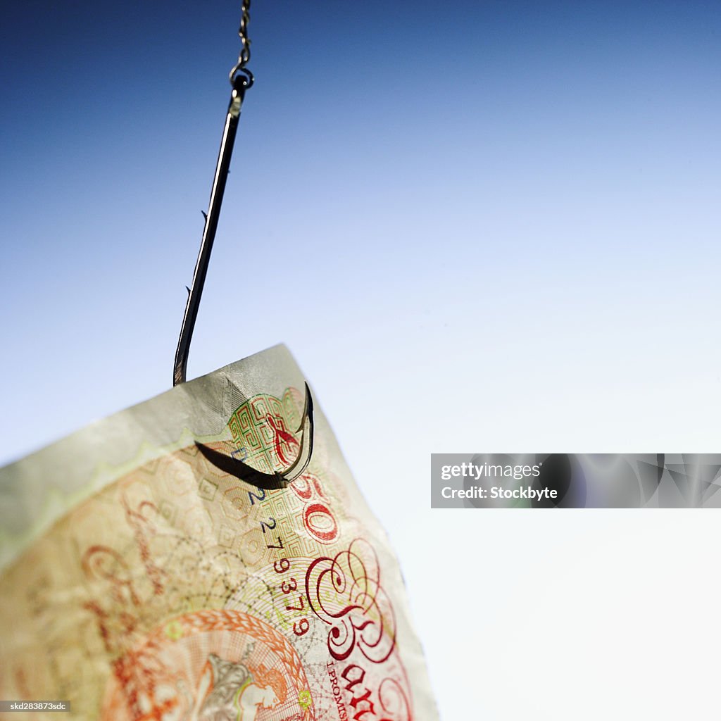 Close-up of a fifty pound note hanging on fishhook