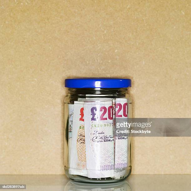 close-up of a jar containing u.k.. pound notes - twenty pound note 個照片及圖片檔