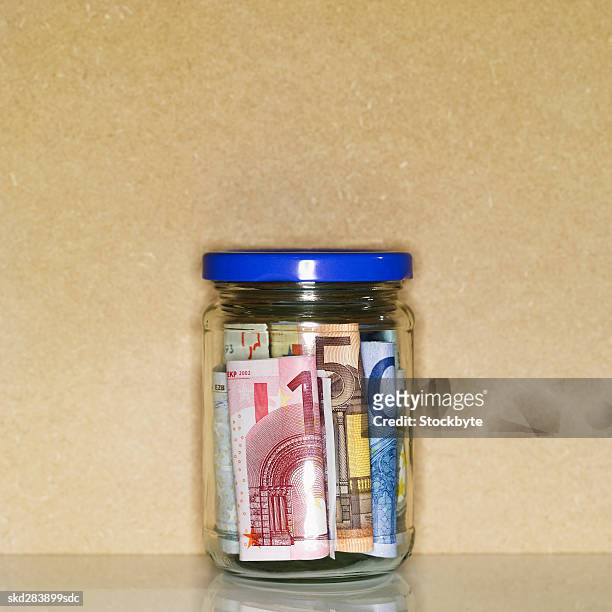close-up of a jar containing euro bank notes - 50 euros stock-fotos und bilder