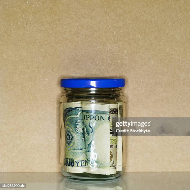 close-up of a jar containing japanese yen bank notes - all asian currencies stock pictures, royalty-free photos & images