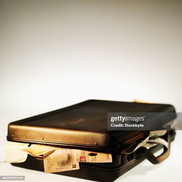 close-up of a briefcase overflowing with u.k.. bank notes - twenty pound note stock pictures, royalty-free photos & images