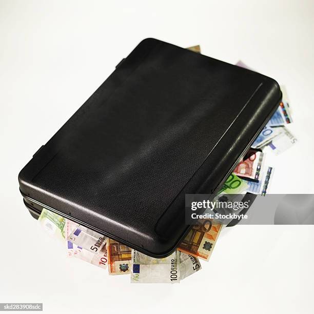 elevated view of a briefcase overflowing with euro bank notes - banconota da venti euro foto e immagini stock