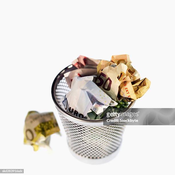 elevated view of crumpled euro bank notes in rubbish bin - euros and trash stockfoto's en -beelden