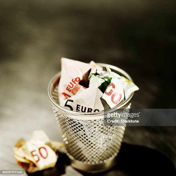 elevated view of crumpled euro bank notes in rubbish bin - 50 euros stock-fotos und bilder