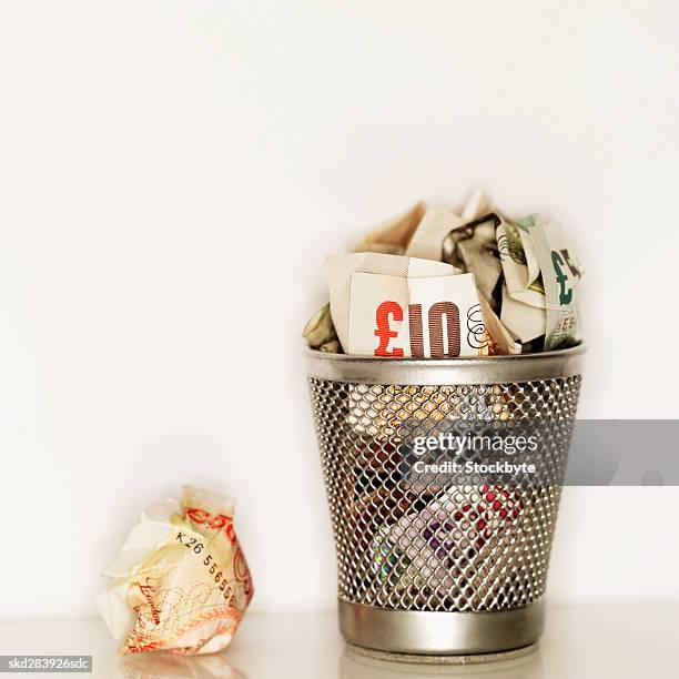 elevated view of crumpled euro bank notes in rubbish bin - 50 euros stock-fotos und bilder