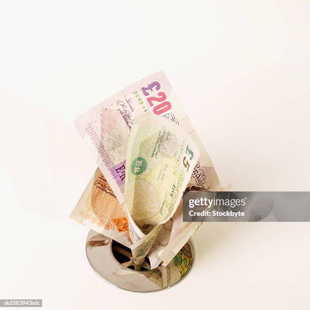 close-up of u.k.. pound notes going down the drain - nota de cinco pounds - fotografias e filmes do acervo