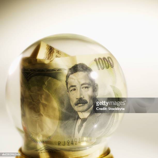 close-up of snow globe containing japanese yen bank notes - all asian currencies stock pictures, royalty-free photos & images