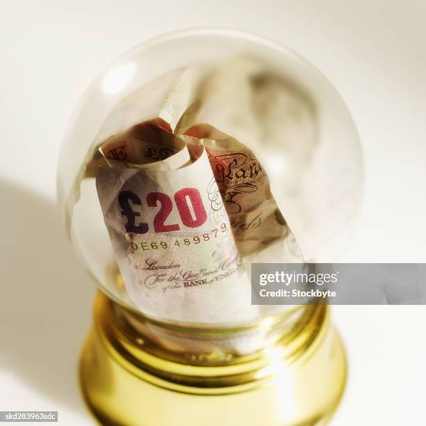 close-up of snow globe containing u.k.. pound notes - twenty pound note stock pictures, royalty-free photos & images