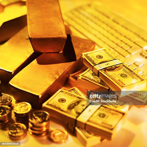 close-up of a stack of gold bars and one hundred dollar bills and one euro coins - stack foto e immagini stock