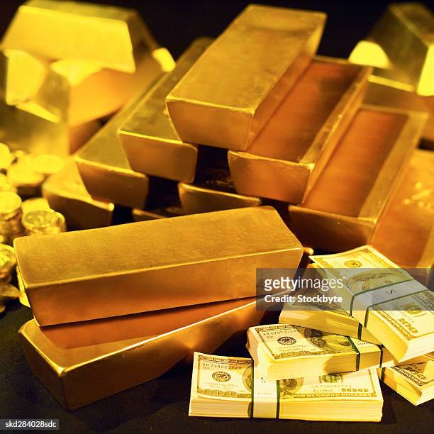 close-up of a stack of gold bars and one hundred dollar bills and one euro coins - stack foto e immagini stock