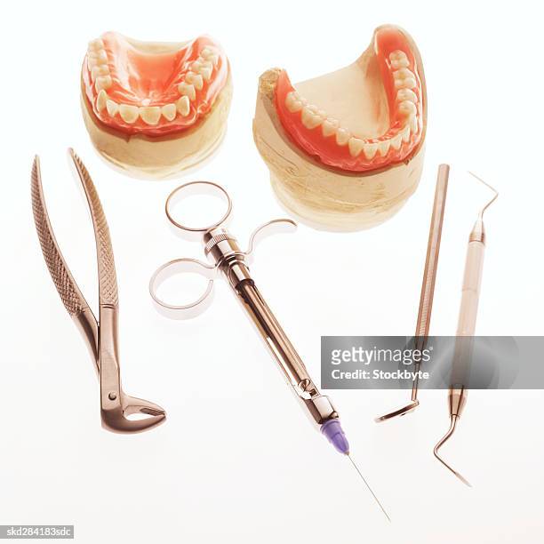 close-up of false teeth and dental tools - plaque remover stock pictures, royalty-free photos & images