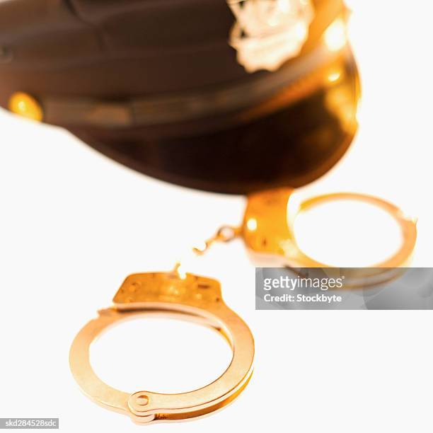 close-up of handcuffs and police hat - hat stock-fotos und bilder