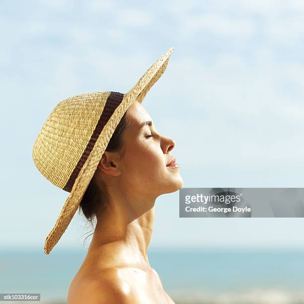 young woman with a straw hat sunbathing - hat stock-fotos und bilder