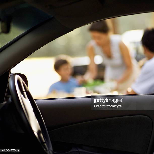 view from the inside of a car of a family having a picnic - inside of ストックフォトと画像