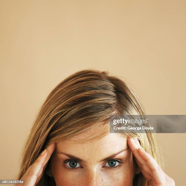 close-up high section of a young woman touching her head - high up ストックフォトと画像