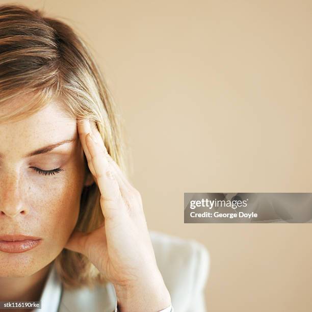 portrait of a young woman with a headache - rub temples stock pictures, royalty-free photos & images