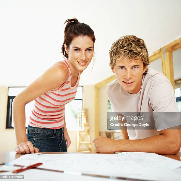 low angle view of a young couple looking at blueprints of a house - kellyanne conway speaks to morning shows from front lawn of white house stockfoto's en -beelden