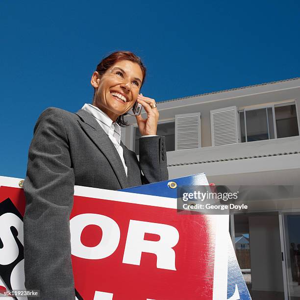 low angle view of a female real estate agent carrying signs - commercial event stockfoto's en -beelden