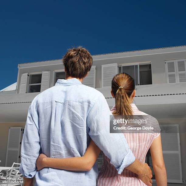 a young couple holding each other and looking at a house - kellyanne conway speaks to morning shows from front lawn of white house stockfoto's en -beelden