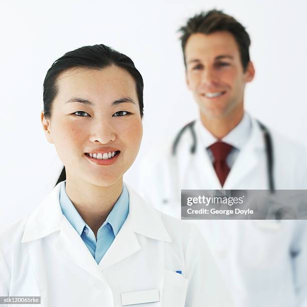 portrait of young doctors in lab coats - lab coat stock-fotos und bilder