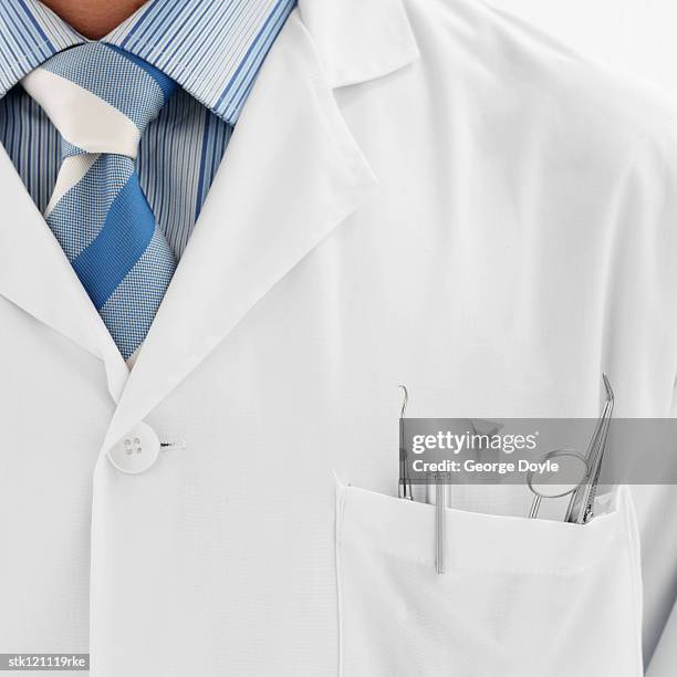 a lab coat with dental instruments in the pocket - lab coat stock-fotos und bilder