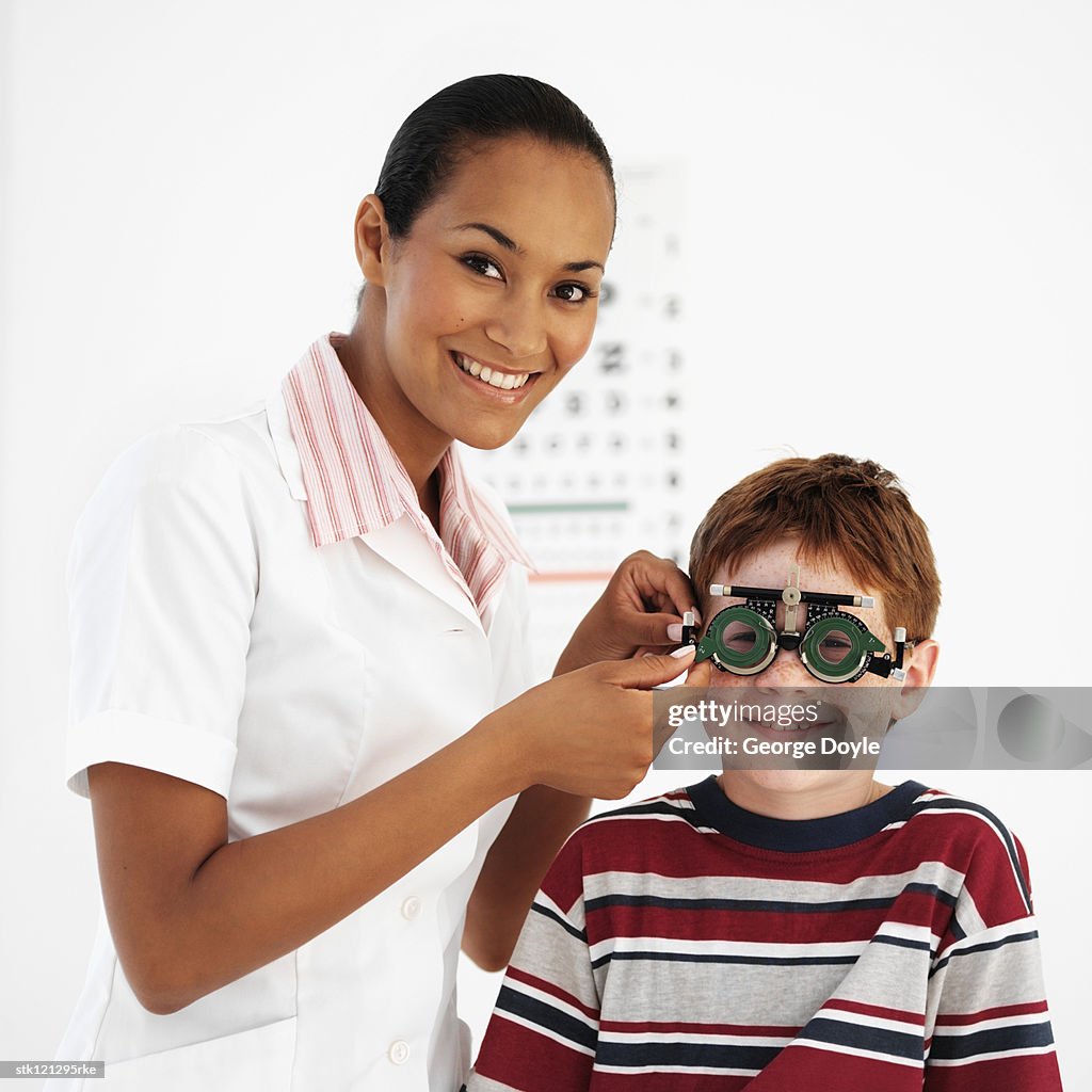 Female optometrist examining a boy's (8-10) eyes
