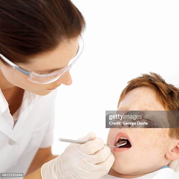 a dentist examining a little boy's teeth - kittle stock-fotos und bilder