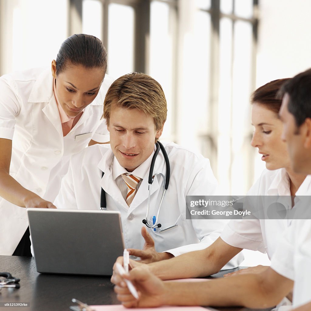 Group of young medical professionals viewing a laptop screen