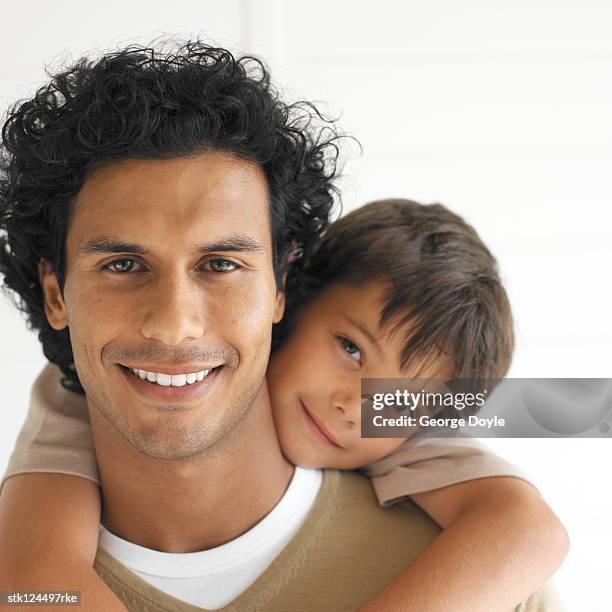 portrait of a son riding on fathers back - backed stock pictures, royalty-free photos & images