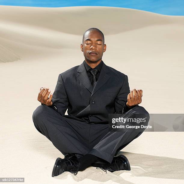 businessman doing yoga in the desert - duing stock pictures, royalty-free photos & images