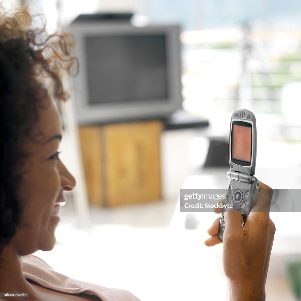 View from behind of a young woman using a mobile phone
