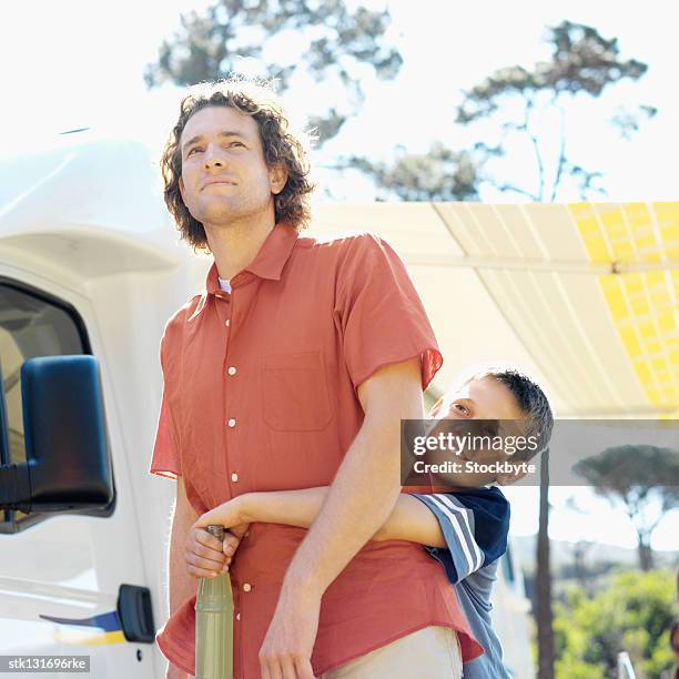 close up of father and son (8-9) hugging holding a bottle of soda - genderblend stock pictures, royalty-free photos & images