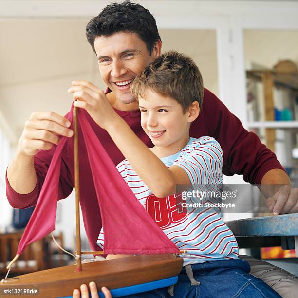 close-up of man helping his son make a miniature ship - make up ストックフォトと画像