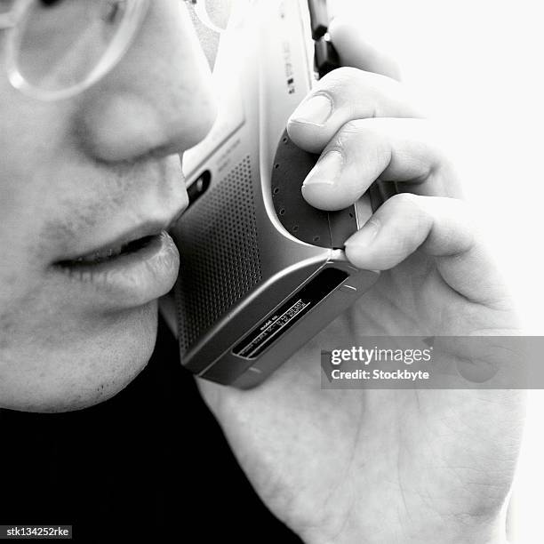 close up of a businessman holding dictaphone up to his ear - dictaphone stock pictures, royalty-free photos & images