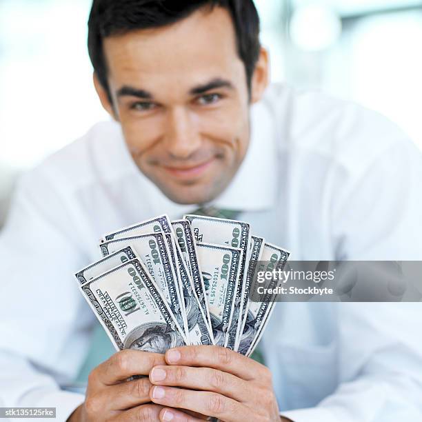 close-up of a businessman holding hundred dollar bills (blurred) - kärleken till pengar bildbanksfoton och bilder