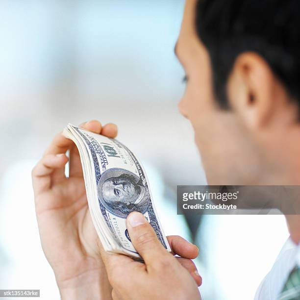 close-up of a man holding a wad of hundred dollar bills - kärleken till pengar bildbanksfoton och bilder