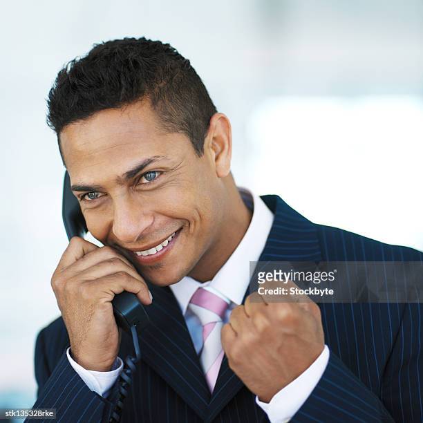 close-up of a businessman talking on the telephone with a smile - man smile stock-fotos und bilder