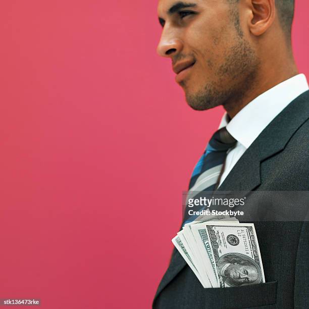 close up side view of businessman showing american dollar notes in his jacket pocket - pink colour scheme stock pictures, royalty-free photos & images