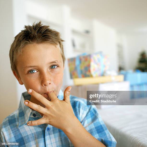 portrait of a young boy licking his finger - lamber imagens e fotografias de stock