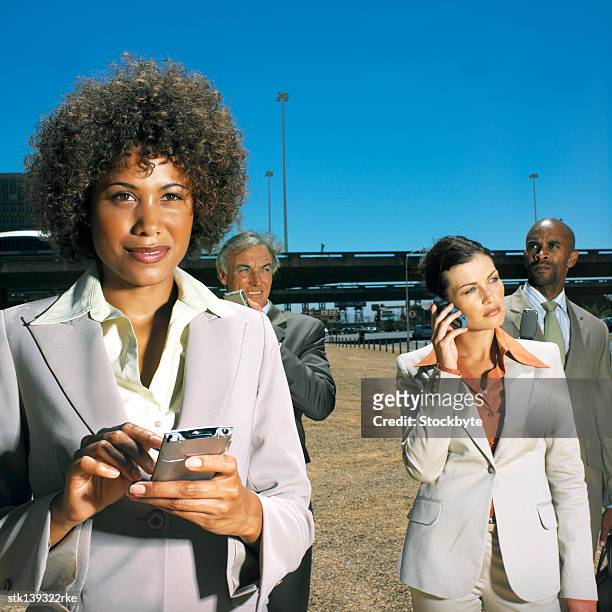 close up of four people businesswoman using personal digital assistants and mobile phones - intersected stock pictures, royalty-free photos & images