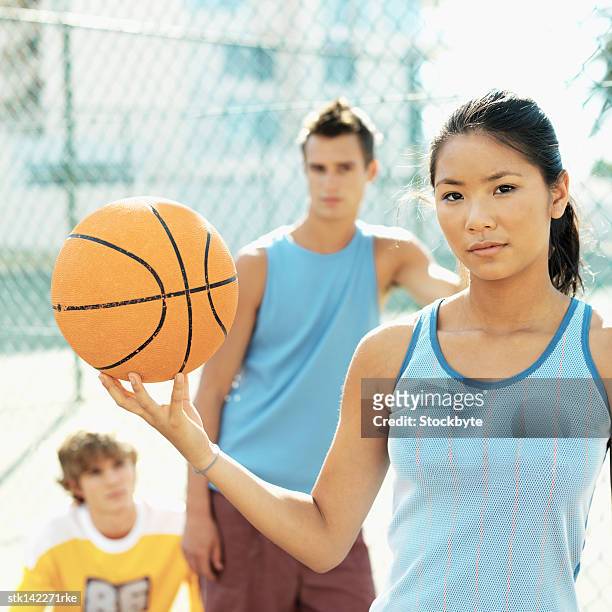 close-up of a teenage girl holding a basketball - woman yellow basketball stock pictures, royalty-free photos & images