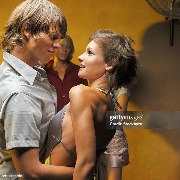 side profile of a young couple dancing at a party and two other people in background - roupa de discoteca imagens e fotografias de stock